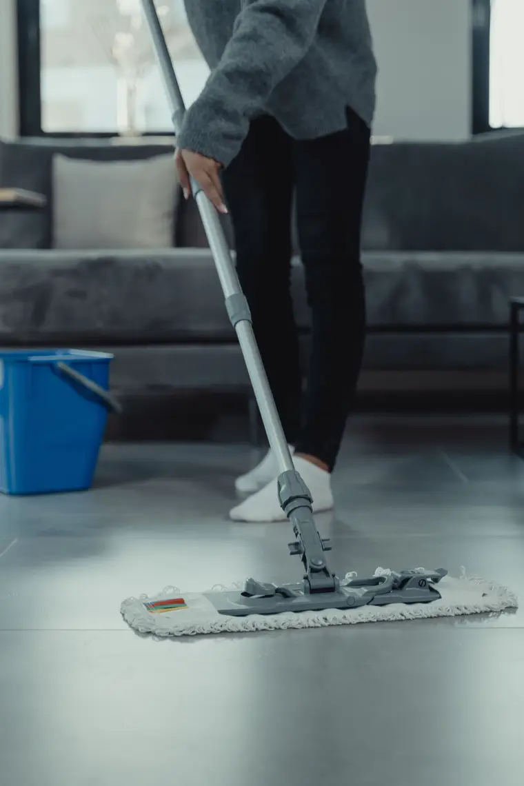 Mopping water from a tiled living-room floor, bucket alongside